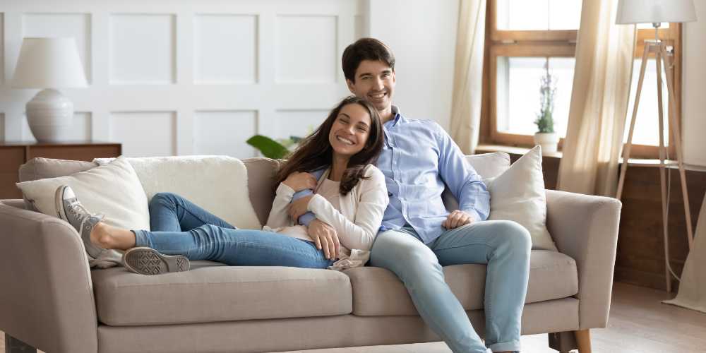 Tenant Find Plymouth - Couple Sitting on a Sofa Smiling - Plymouth Homes Tenant Find Plymouth - Couple Sitting on a Sofa Smiling - Plymouth Homes